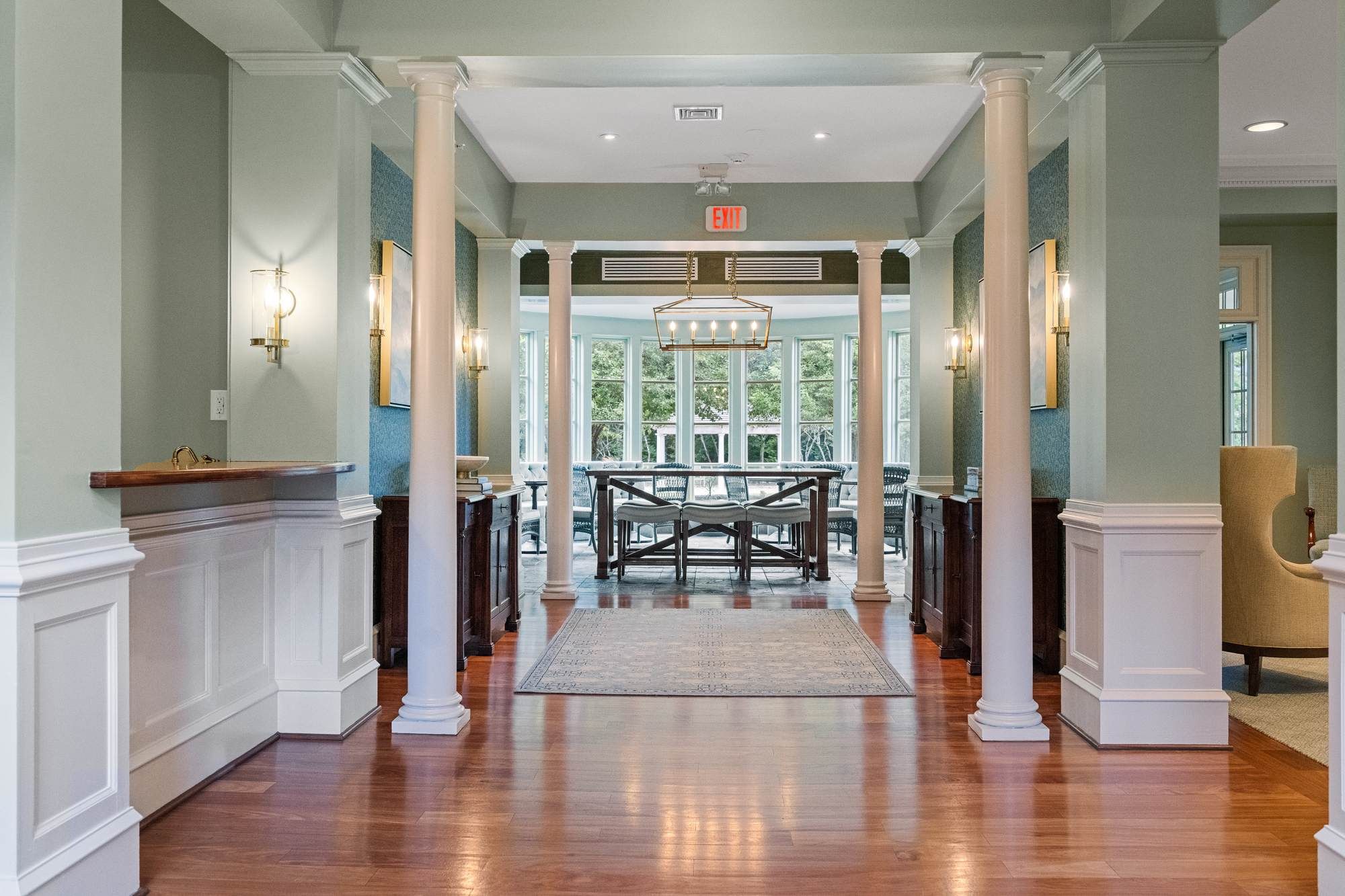 Community clubhouse entry with classic columns, wood flooring, and natural light at Jacobs Woods in Lansdale, PA.